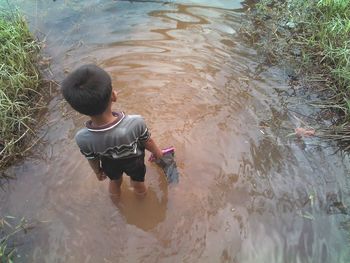 High angle view of boy playing in river