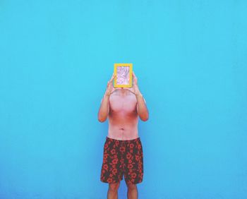 Girl standing against blue wall