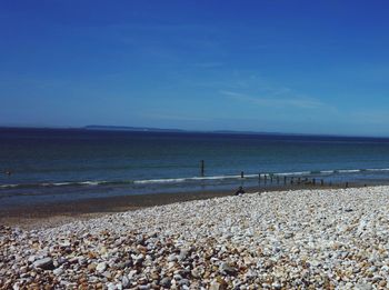 Scenic view of beach against blue sky