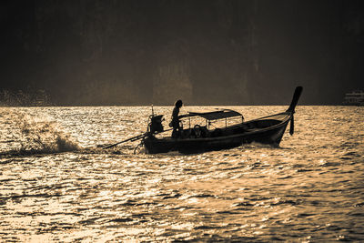 Silhouette boat sailing in sea against sky