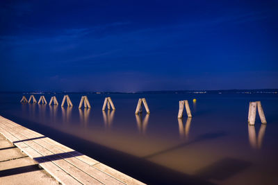 Swimming pool by sea against blue sky