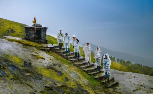 People walking on mountain against sky