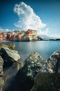 Scenic view of sea by buildings against sky