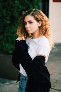 Beautiful young woman standing on footpath