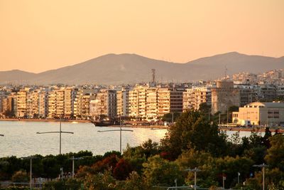 View of townscape by mountains against clear sky