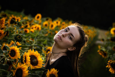 Portrait of young woman with yellow flowering plants