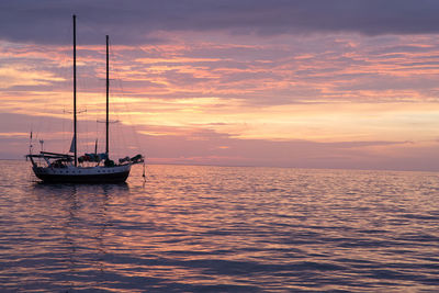 Boat sailing in sea at sunset