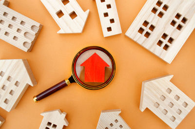 Magnifying glass and wooden houses. house searching concept. home appraisal. 