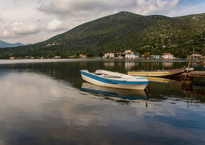 Boat moored in lake against sky