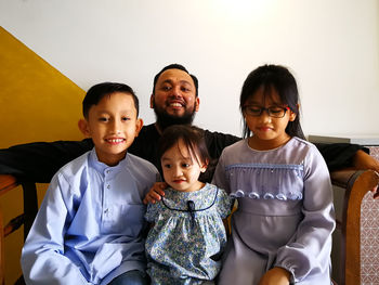 Portrait of happy family sitting at home on eid-ul-fitr