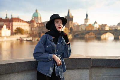 Young woman standing against buildings