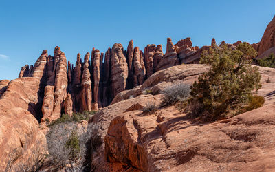 Full frame view of vertical fin-like sandstone formations against a clear blue sky