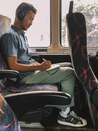 Man sitting on seat in bus