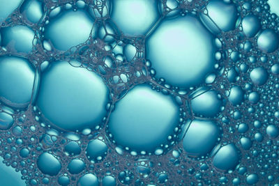 Closeup bubbles in water. oil drops on a water surface abstract background.