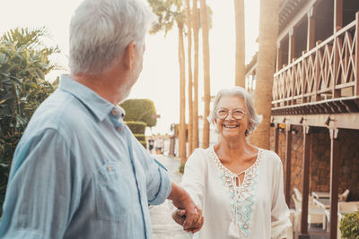 Side view of couple standing against wall