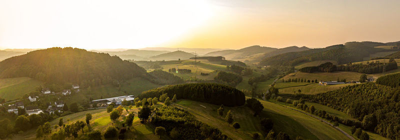 Scenic view of agricultural landscape against sky during sunset