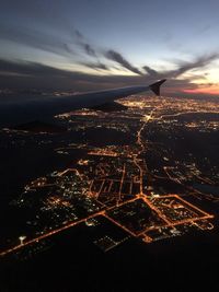 Aerial view of illuminated cityscape against sky during sunset