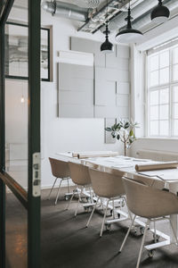 Chairs and tables arranged in empty meeting room at office