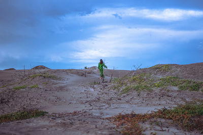 Woman walking on sand dune in desert