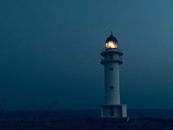 Lighthouse against sky at night