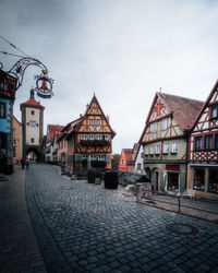 Houses by street in town against sky