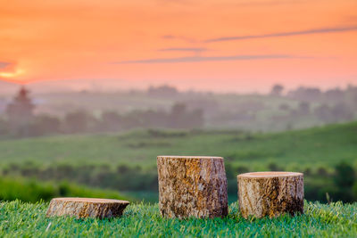 Hay bales on field against sky during sunset