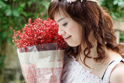 Smiling young woman holding bouquet