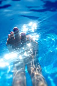 Low section of person swimming in pool