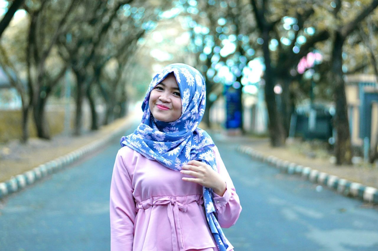 PORTRAIT OF SMILING WOMAN WITH UMBRELLA