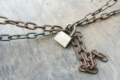Close-up of chain with padlock on wooden table