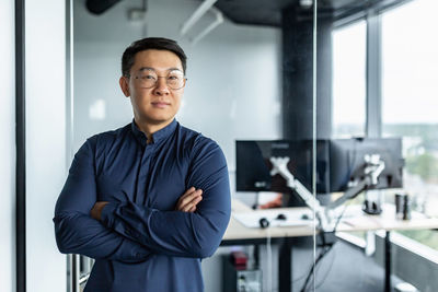 Portrait of young man standing in office