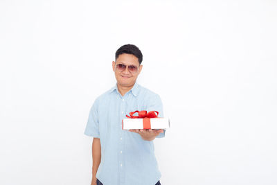 Portrait of smiling man standing against white background