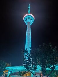 Low angle view of communications tower at night