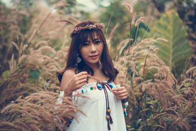 Portrait of woman standing by plants