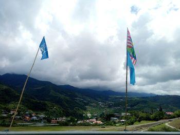 Low angle view of flags on mountain against sky
