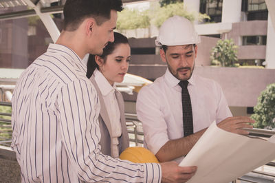 Architects discussing on bridge in city