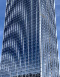 Low angle view of modern building against blue sky