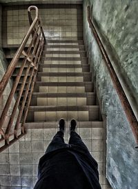 Low section of man standing on staircase