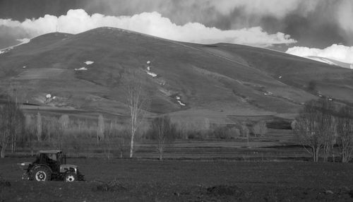 Scenic view of field and mountains against sky