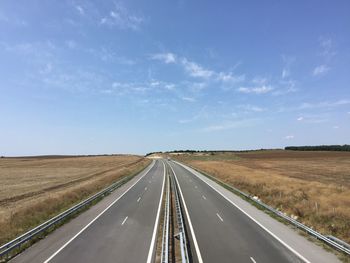 Road by landscape against sky