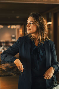 Thoughtful confident mid adult female professional looking away at law office