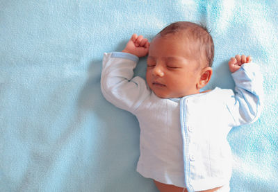 High angle view of baby sleeping on bed