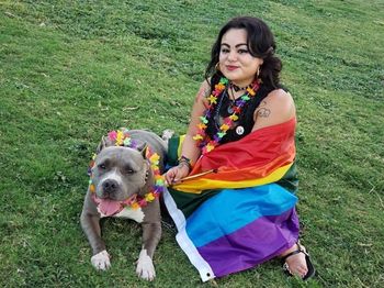 Young woman with dog sitting on field