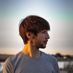 Portrait of young man against sky during sunset