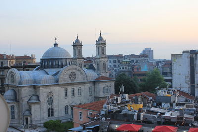 Buildings in city against sky during sunset