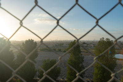 Scenic view of field seen through chainlink fence
