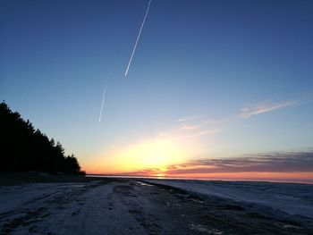 Scenic view of snow covered landscape against sky during sunset