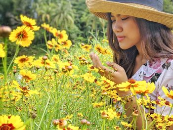 Low angle view of woman on yellow flowering plants