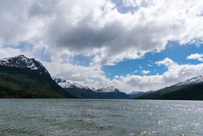 Scenic view of lake by mountains against sky