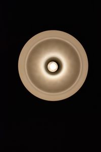 Close-up of illuminated light bulb against black background